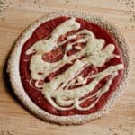 Tortilla pizza with cashew mozzarella on a wooden board.